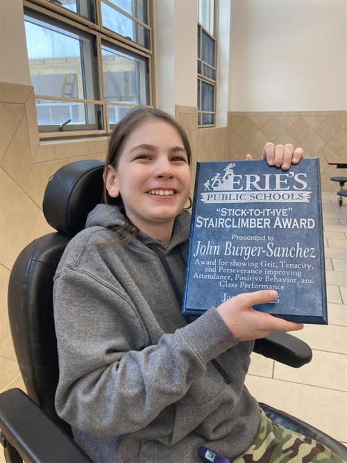 John Burger-Sanchez, Strong VIncent's Stairclimber recipient for January, poses with his plaque.